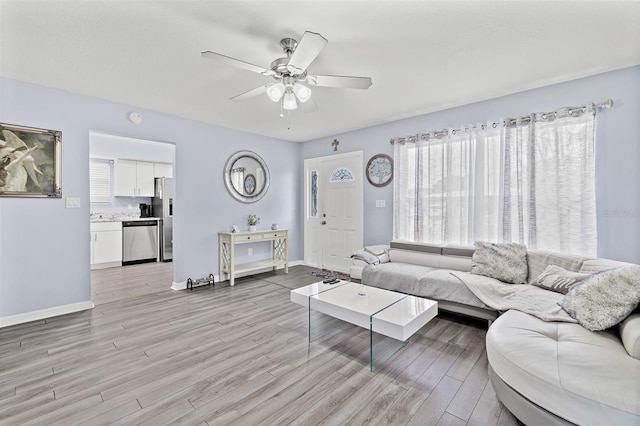 living area featuring light wood finished floors and ceiling fan