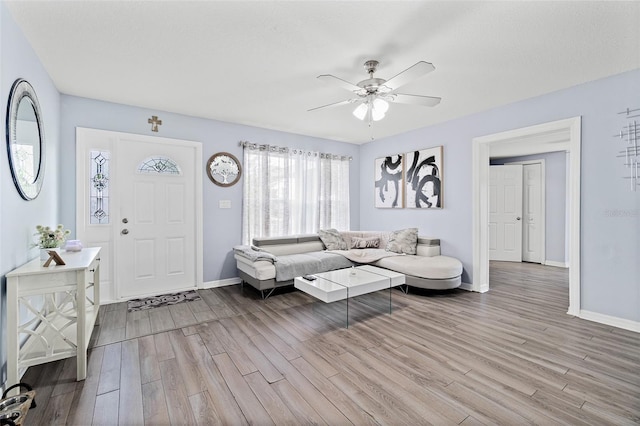 living room with light wood-type flooring and a ceiling fan