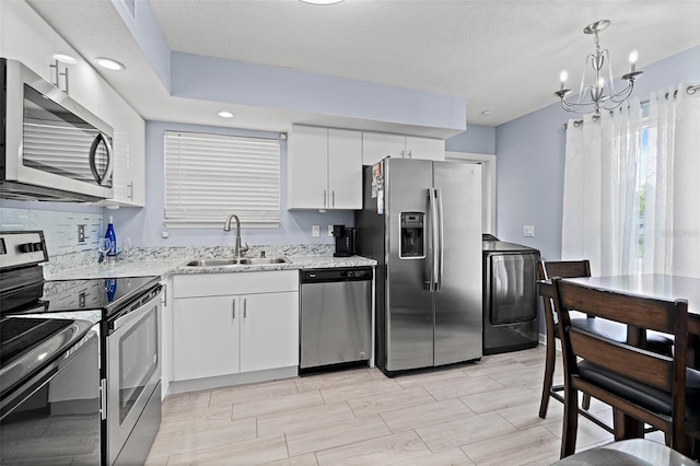 kitchen featuring stainless steel appliances, washer / dryer, white cabinets, light stone counters, and recessed lighting