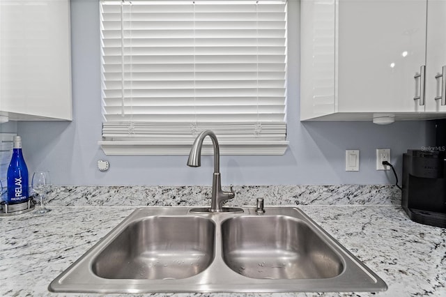 kitchen view of white cabinetry and light stone counters