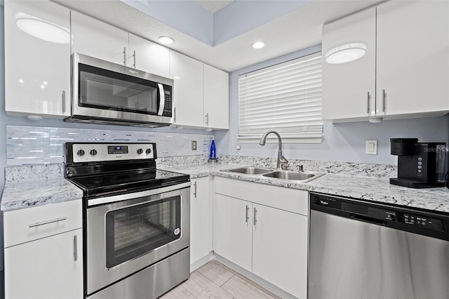 kitchen featuring appliances with stainless steel finishes, white cabinets, tasteful backsplash, and recessed lighting