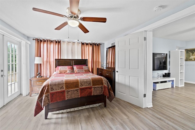 bedroom with access to outside, light wood-style floors, and a ceiling fan