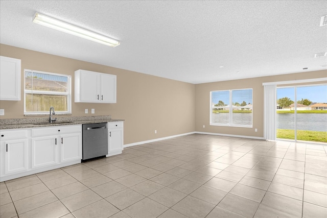 15175 Sugargrove Way, Orlando, FL 32828 - kitchen featuring stainless steel dishwasher, a textured ceiling, open floor plan, white cabinetry, and light tile patterned flooring