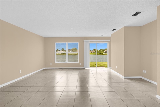 15175 Sugargrove Way, Orlando, FL 32828 - unfurnished room with light tile patterned floors, a textured ceiling, and a water view