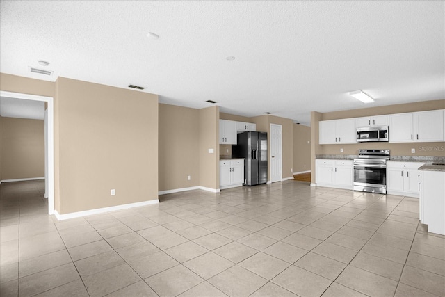 15175 Sugargrove Way, Orlando, FL 32828 - kitchen featuring appliances with stainless steel finishes, open floor plan, light tile patterned floors, a textured ceiling, and white cabinets