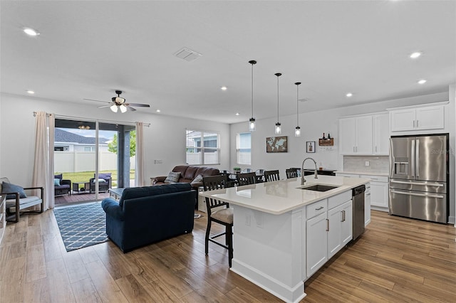 2936 Wild Mulberry Dr, Clermont, FL 34711 - kitchen featuring appliances with stainless steel finishes, open floor plan, light countertops, an island with sink, and recessed lighting