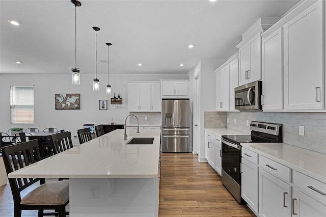 2936 Wild Mulberry Dr, Clermont, FL 34711 - kitchen with appliances with stainless steel finishes, a breakfast bar area, light wood-style flooring, recessed lighting, and tasteful backsplash
