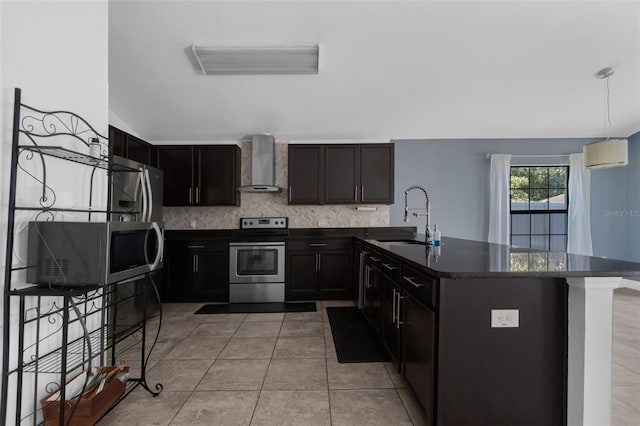 305 Chelmsford Ct, Kissimmee, FL 34758 - kitchen featuring stainless steel appliances, wall chimney exhaust hood, dark countertops, decorative backsplash, and a peninsula