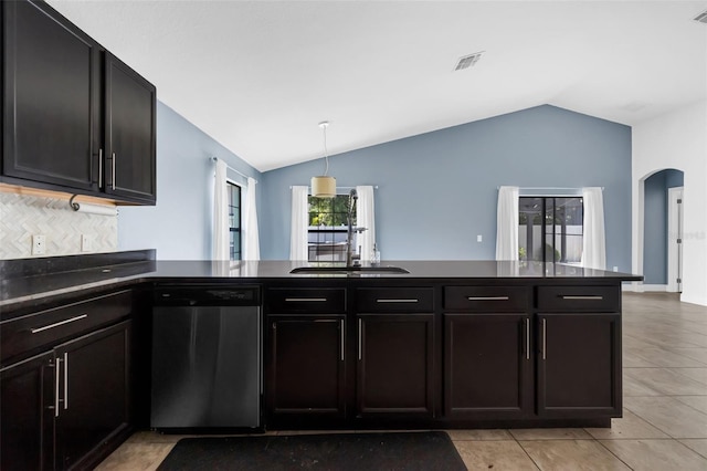305 Chelmsford Ct, Kissimmee, FL 34758 - kitchen featuring stainless steel dishwasher, vaulted ceiling, arched walkways, and dark countertops