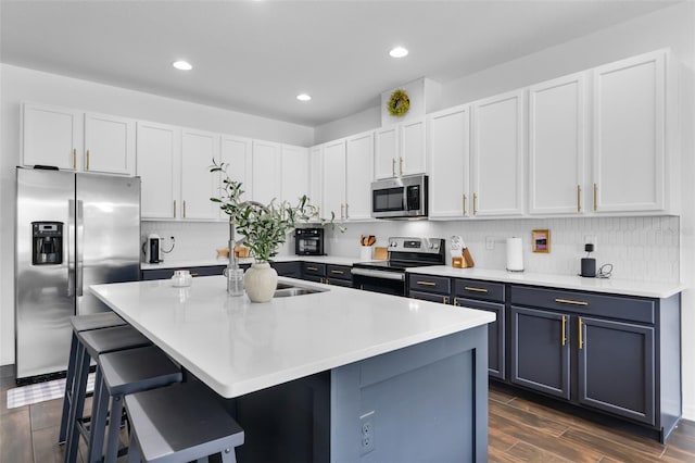 17242 Hickory Wind Dr, Clermont, FL 34711 - kitchen featuring stainless steel appliances, a kitchen bar, an island with sink, decorative backsplash, and light countertops
