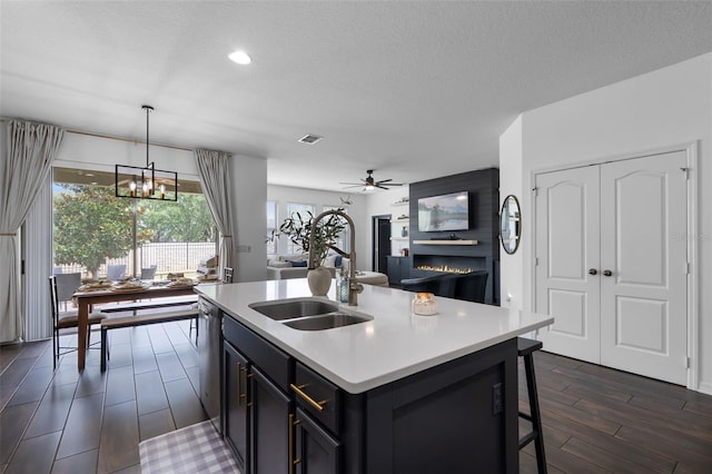 17242 Hickory Wind Dr, Clermont, FL 34711 - kitchen featuring light countertops, dark wood-style flooring, ceiling fan, a kitchen breakfast bar, and a center island with sink