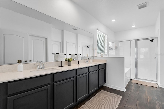 17242 Hickory Wind Dr, Clermont, FL 34711 - bathroom with a shower stall, double vanity, a garden tub, recessed lighting, and wood finished floors