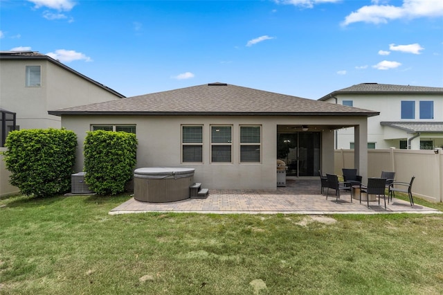 17242 Hickory Wind Dr, Clermont, FL 34711 - rear view of house featuring a hot tub, ceiling fan, stucco siding, a patio, and a shingled roof