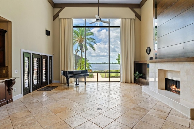10545 Down Lakeview Cir, Windermere, FL 34786 - dining area featuring a water view, a ceiling fan, a high end fireplace, stone tile flooring, and a towering ceiling