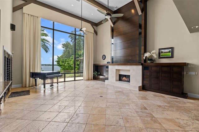 10545 Down Lakeview Cir, Windermere, FL 34786 - living room with a towering ceiling, a ceiling fan, a fireplace, stone tile flooring, and a water view