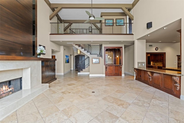10545 Down Lakeview Cir, Windermere, FL 34786 - unfurnished living room featuring a premium fireplace, a high ceiling, ceiling fan, stairs, and stone tile flooring