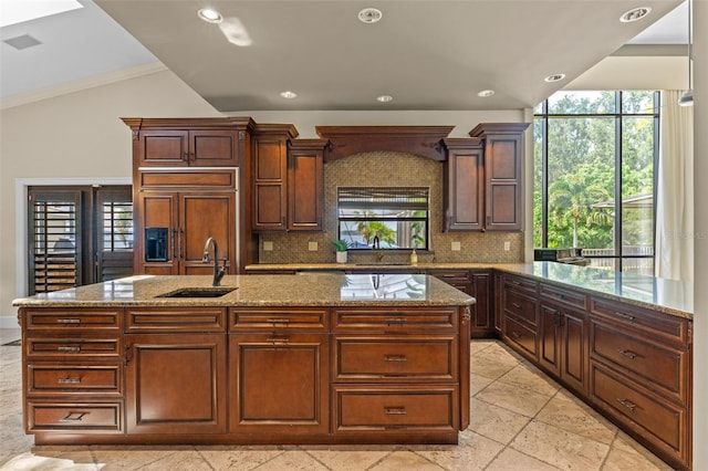 10545 Down Lakeview Cir, Windermere, FL 34786 - kitchen with vaulted ceiling, tasteful backsplash, light stone countertops, a kitchen island with sink, and recessed lighting