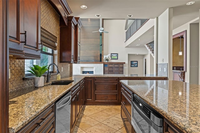 10545 Down Lakeview Cir, Windermere, FL 34786 - kitchen with stainless steel dishwasher, decorative backsplash, light stone counters, ceiling fan, and recessed lighting