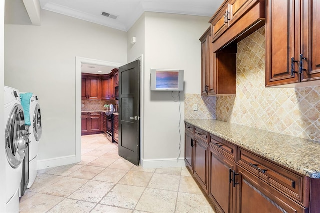 10545 Down Lakeview Cir, Windermere, FL 34786 - laundry room with washing machine and clothes dryer, cabinet space, crown molding, and stone tile floors
