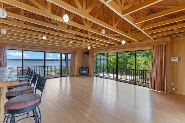 10545 Down Lakeview Cir, Windermere, FL 34786 - living room featuring a wood stove, wooden walls, plenty of natural light, wood finished floors, and a water view