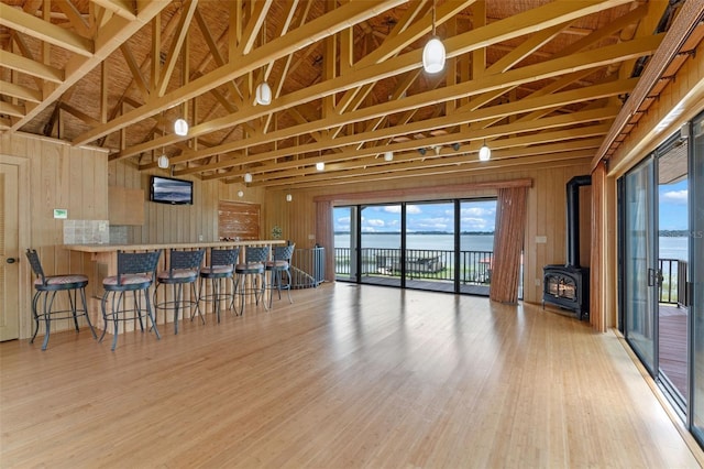 10545 Down Lakeview Cir, Windermere, FL 34786 - kitchen featuring a wood stove, a kitchen breakfast bar, wood finished floors, wood walls, and open floor plan