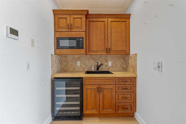 10545 Down Lakeview Cir, Windermere, FL 34786 - kitchen with wine cooler, black microwave, tasteful backsplash, ornamental molding, and brown cabinets
