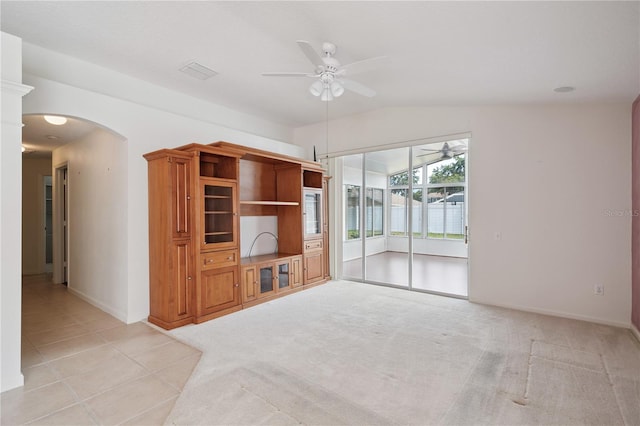 1762 Laurel Brook Loop, Casselberry, FL 32707 - unfurnished living room with ceiling fan, arched walkways, lofted ceiling, light tile patterned floors, and light colored carpet