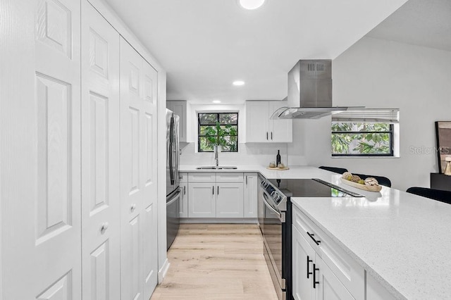 1870 Whispering Way, Tarpon Springs, FL 34689 - kitchen featuring stainless steel appliances, island range hood, white cabinets, light wood-style flooring, and recessed lighting