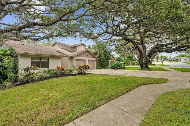 1870 Whispering Way, Tarpon Springs, FL 34689 - view of home's exterior featuring concrete driveway, a garage, a yard, a shingled roof, and stucco siding