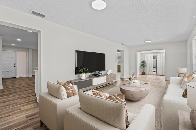 671 25th St SW, Largo, FL 33770 - living area with wood finished floors, a textured ceiling, and recessed lighting
