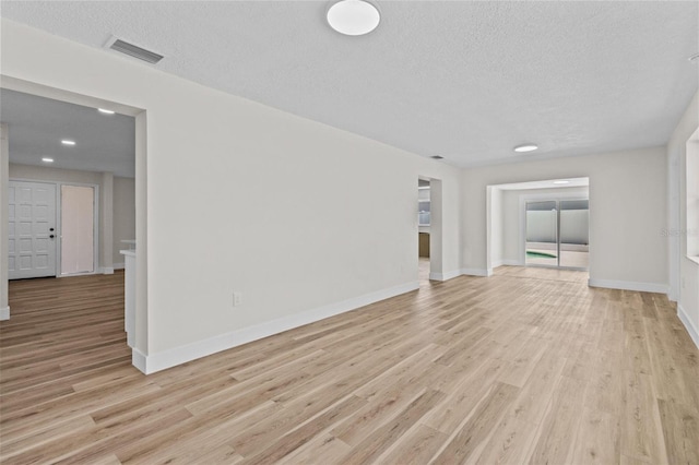 671 25th St SW, Largo, FL 33770 - spare room featuring a textured ceiling, light wood-type flooring, and recessed lighting
