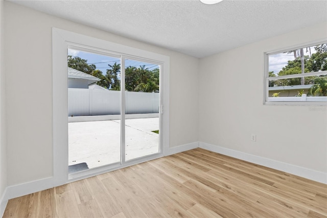 671 25th St SW, Largo, FL 33770 - spare room with healthy amount of natural light, wood finished floors, and a textured ceiling