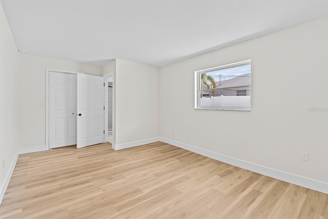 671 25th St SW, Largo, FL 33770 - empty room featuring baseboards and light wood-type flooring