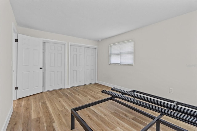 671 25th St SW, Largo, FL 33770 - unfurnished bedroom featuring two closets and light wood-style floors