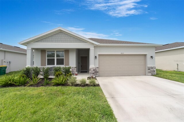 4021 Mayhill Loop, Eustis, FL 32736 - view of front of home with stone siding, a garage, concrete driveway, and a front yard
