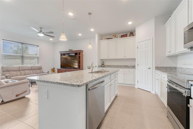 4021 Mayhill Loop, Eustis, FL 32736 - kitchen with stainless steel appliances, open floor plan, light tile patterned floors, ceiling fan, and a kitchen island with sink