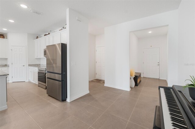 4021 Mayhill Loop, Eustis, FL 32736 - kitchen featuring stainless steel appliances, white cabinetry, light tile patterned floors, recessed lighting, and light stone countertops