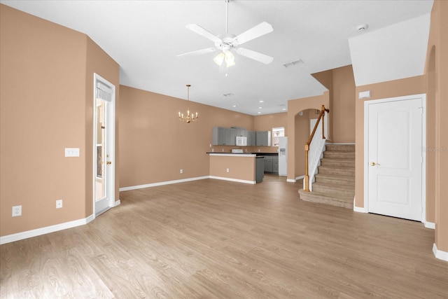 516 Brunello Dr, Davenport, FL 33897 - unfurnished living room featuring a ceiling fan, a chandelier, stairs, and light wood-type flooring