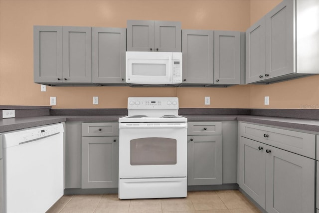 516 Brunello Dr, Davenport, FL 33897 - kitchen featuring white appliances, gray cabinetry, and light tile patterned flooring