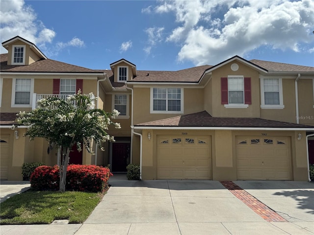 3069 Ashland Ln N, Kissimmee, FL 34741 - view of property with driveway, an attached garage, and stucco siding