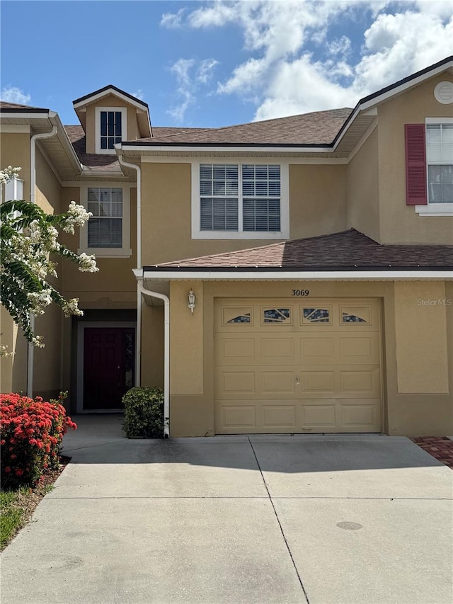 3069 Ashland Ln N, Kissimmee, FL 34741 - multi unit property featuring driveway, a garage, and stucco siding