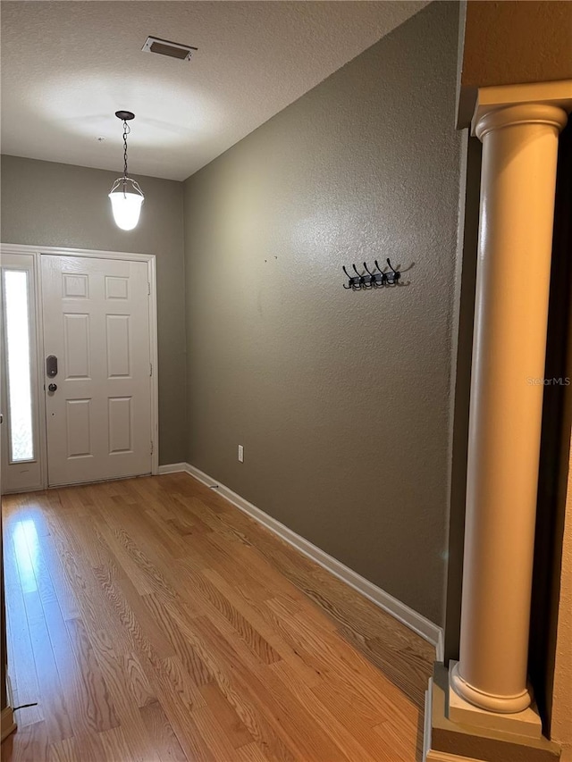 3069 Ashland Ln N, Kissimmee, FL 34741 - entryway with light wood-style floors and decorative columns