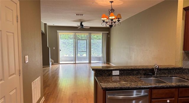 3069 Ashland Ln N, Kissimmee, FL 34741 - kitchen with dishwasher, light wood finished floors, dark stone counters, open floor plan, and a ceiling fan