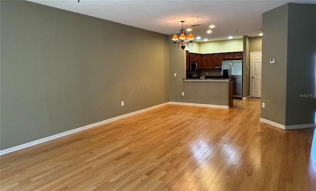 3069 Ashland Ln N, Kissimmee, FL 34741 - kitchen with appliances with stainless steel finishes, a chandelier, open floor plan, light wood-style floors, and recessed lighting