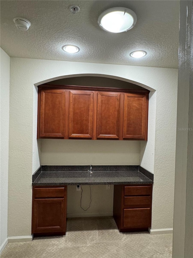 3069 Ashland Ln N, Kissimmee, FL 34741 - unfurnished office featuring built in desk, a textured ceiling, light colored carpet, and a textured wall