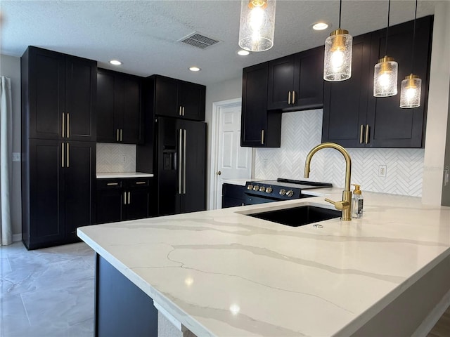 633 Flower Fields Ln, Orlando, FL 32824 - kitchen with black refrigerator with ice dispenser, dark cabinetry, light stone countertops, a peninsula, and recessed lighting