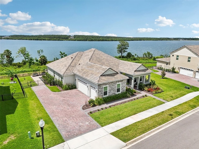 17838 Hither Hills Cir, Winter Garden, FL 34787 - view of front of house featuring stone siding, decorative driveway, a water view, and a garage