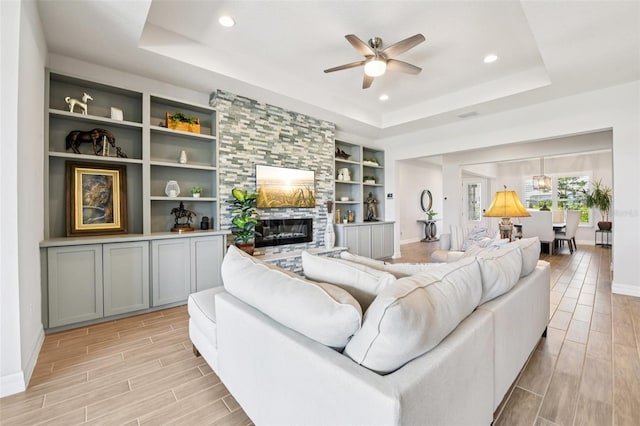 17838 Hither Hills Cir, Winter Garden, FL 34787 - living room with a raised ceiling, wood tiled floors, a ceiling fan, a fireplace, and recessed lighting