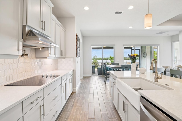 17838 Hither Hills Cir, Winter Garden, FL 34787 - kitchen with black electric cooktop, under cabinet range hood, dishwasher, healthy amount of natural light, and recessed lighting