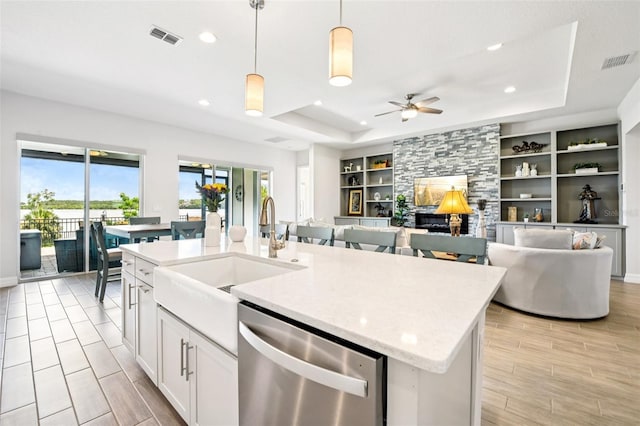 17838 Hither Hills Cir, Winter Garden, FL 34787 - kitchen with stainless steel dishwasher, a tray ceiling, ceiling fan, an island with sink, and recessed lighting